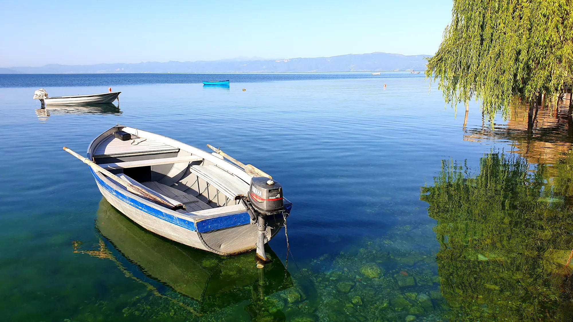 A wooden boat resting on the still, clear water of Lake Ohrid